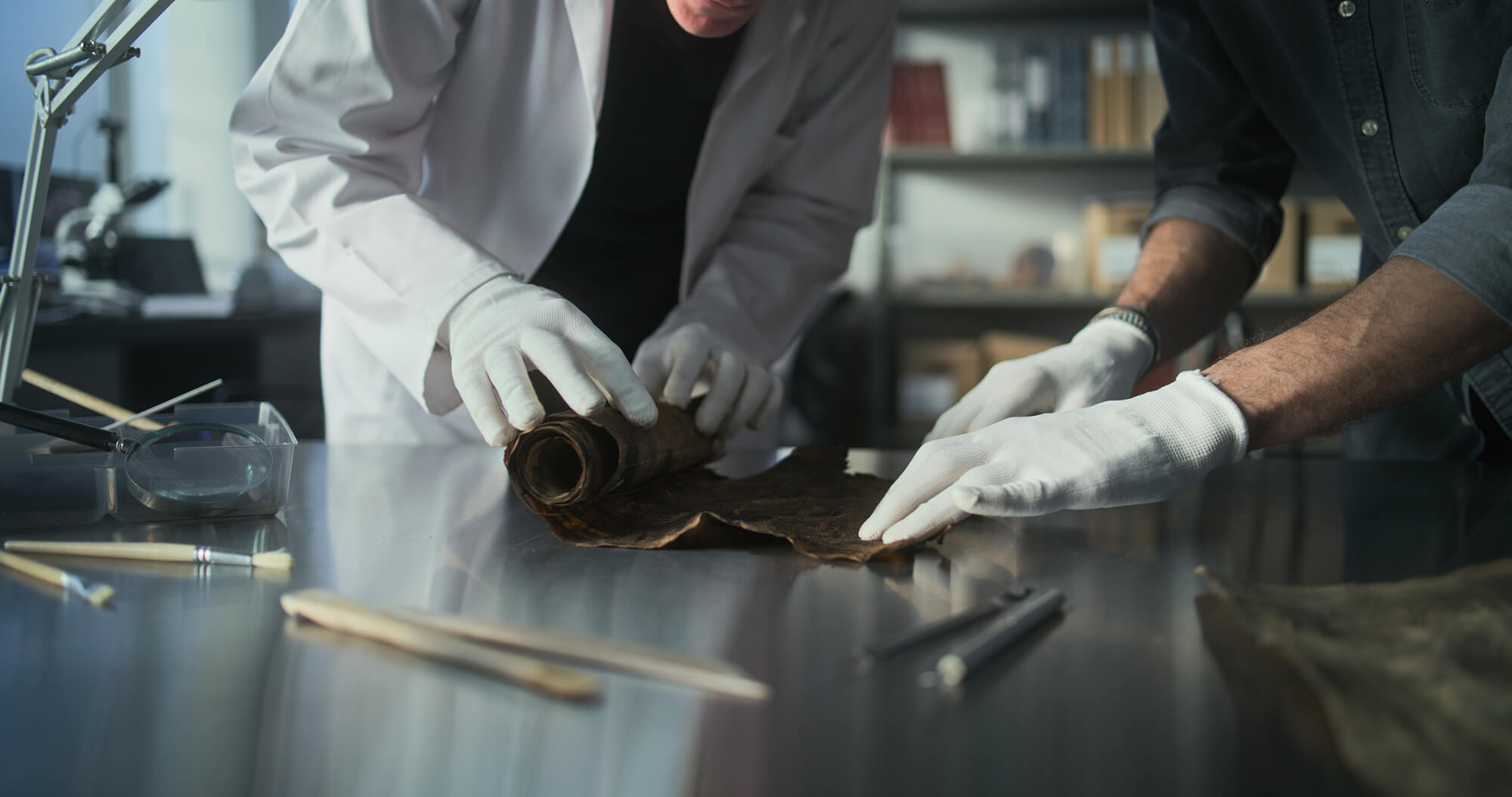Opening a papyrus scroll to verify artwork authenticity