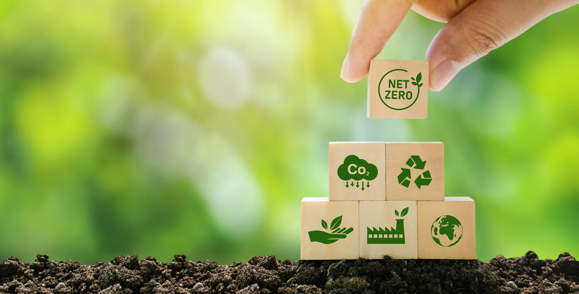Hand assembling blocks representing biogas, green industry, and bio-based carbon analysis under ASTM D6866