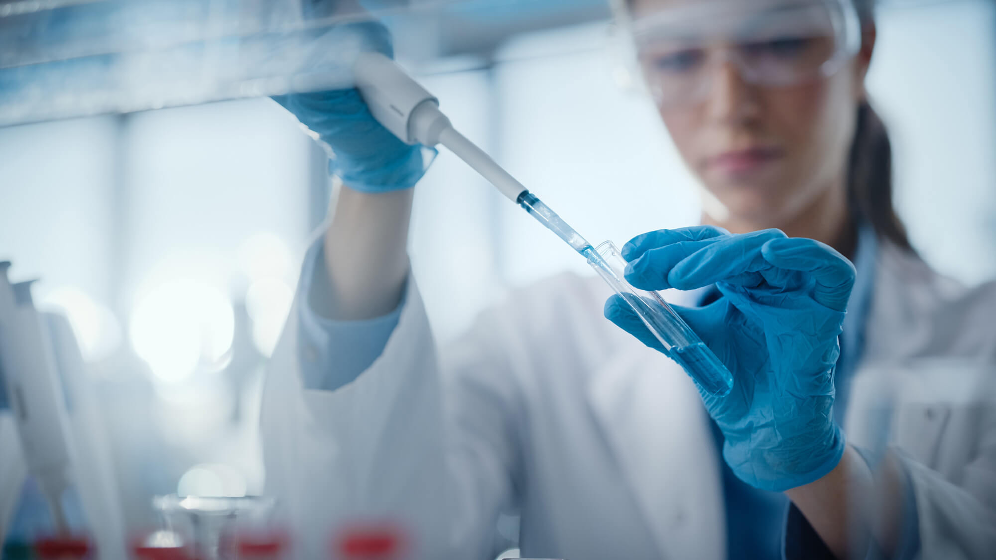 Scientist handling a liquid sample in a laboratory to perform dating analyses
