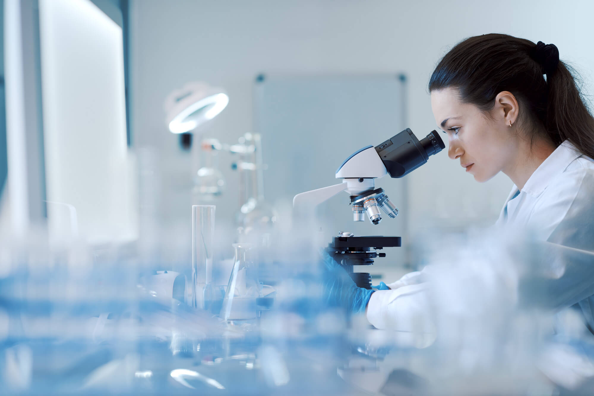 A scientist using a microscope in an accredited laboratory